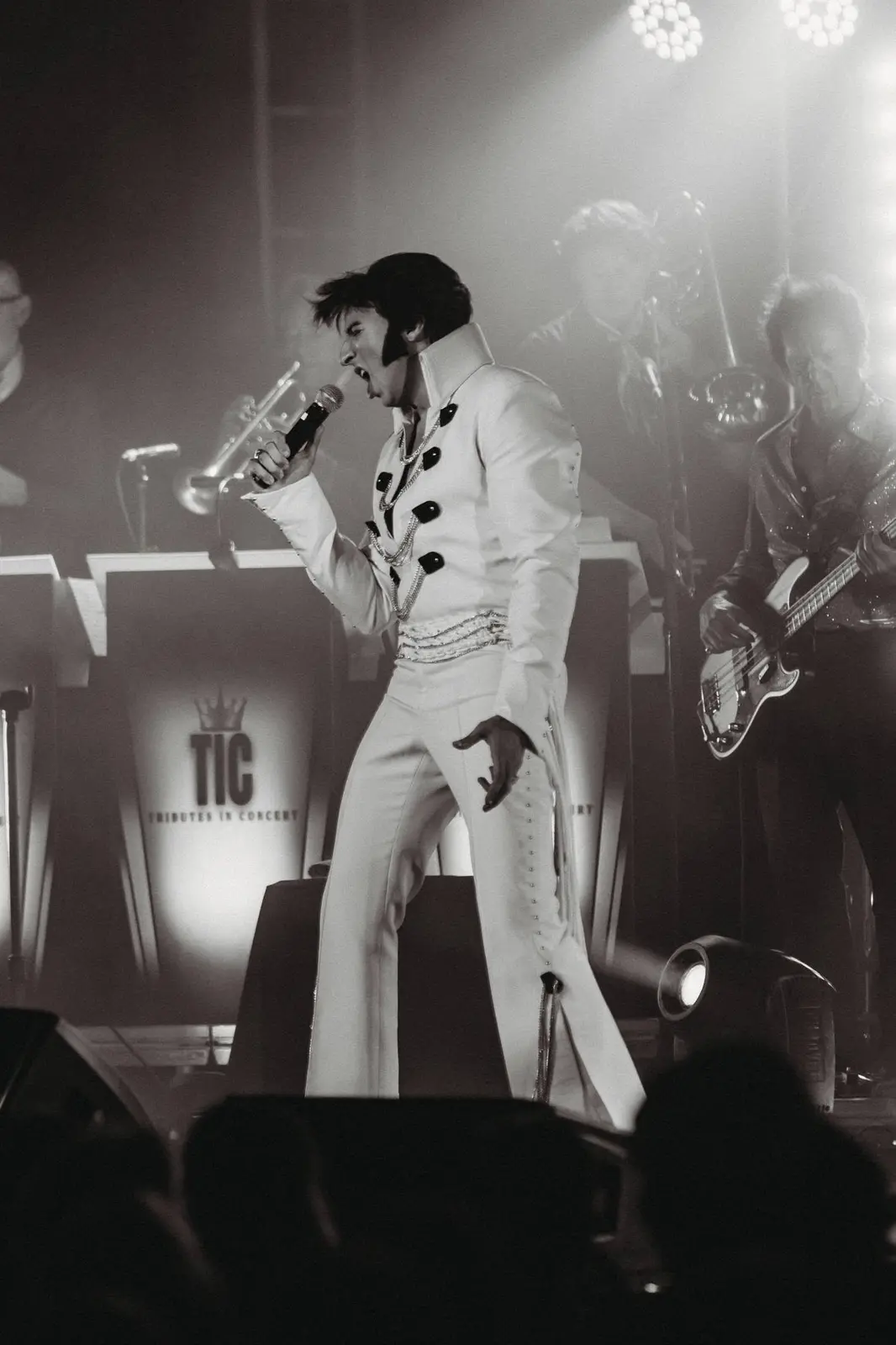 Elvis tribute artist in a spotlight pose, black and white