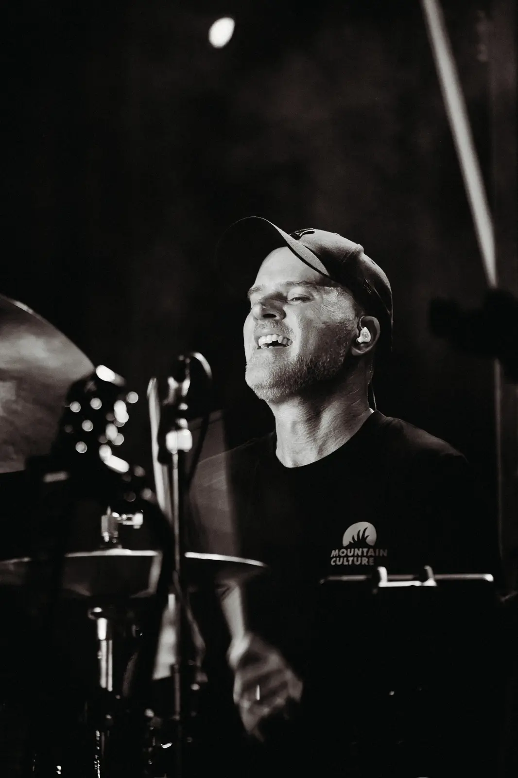 Drummer smiling behind the kit, black and white