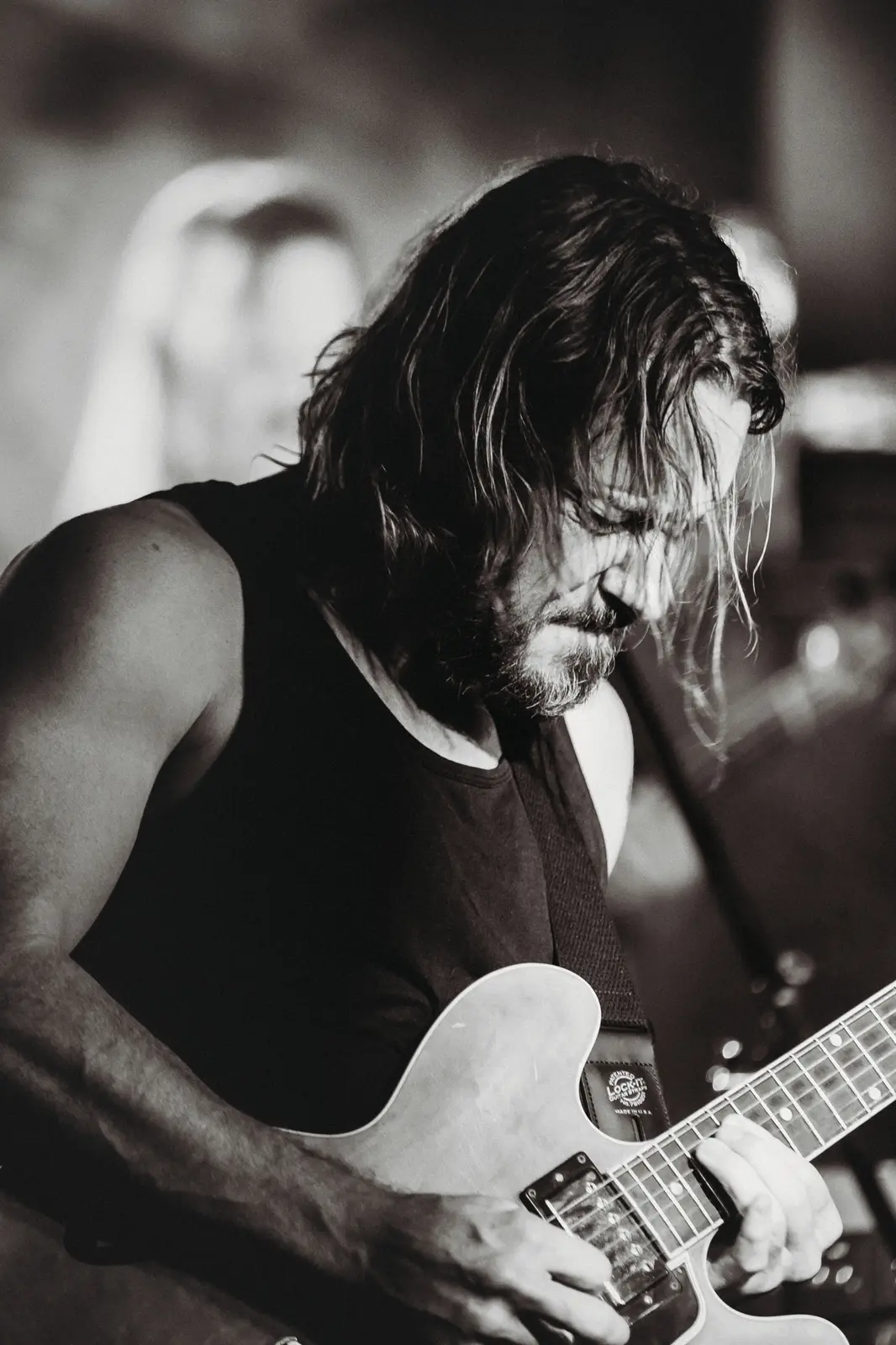 Guitarist head down over the fretboard, black and white