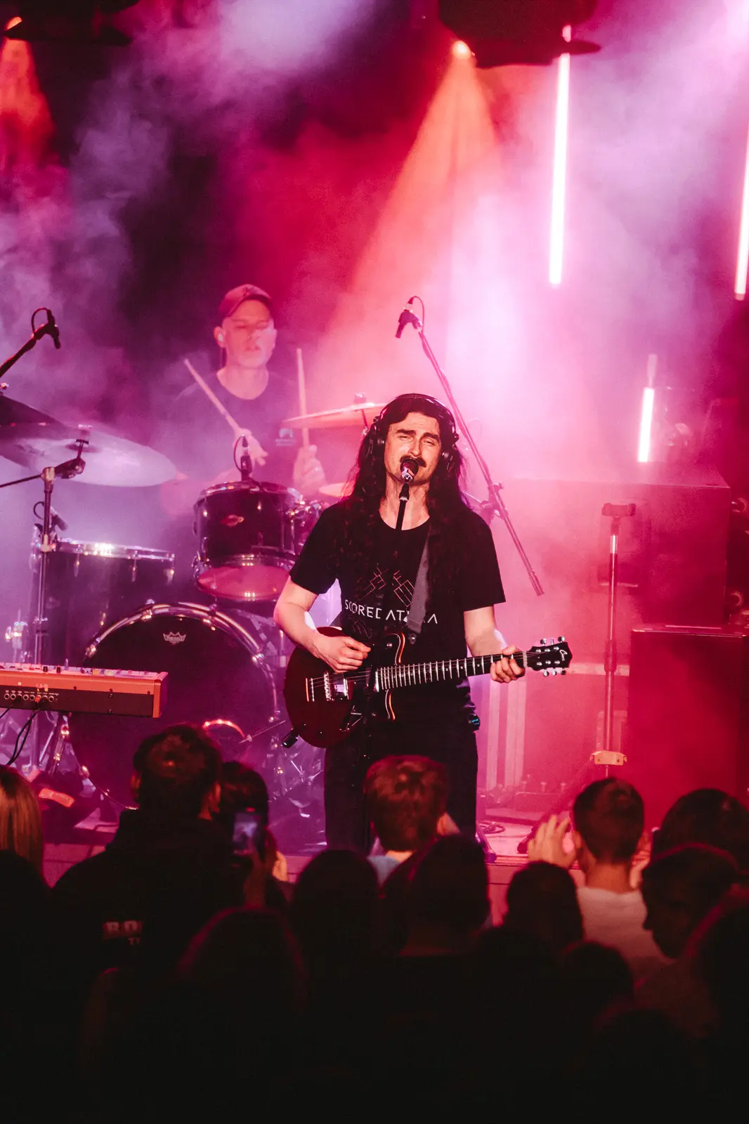 Stage bathed in magenta with the crowd pressed close