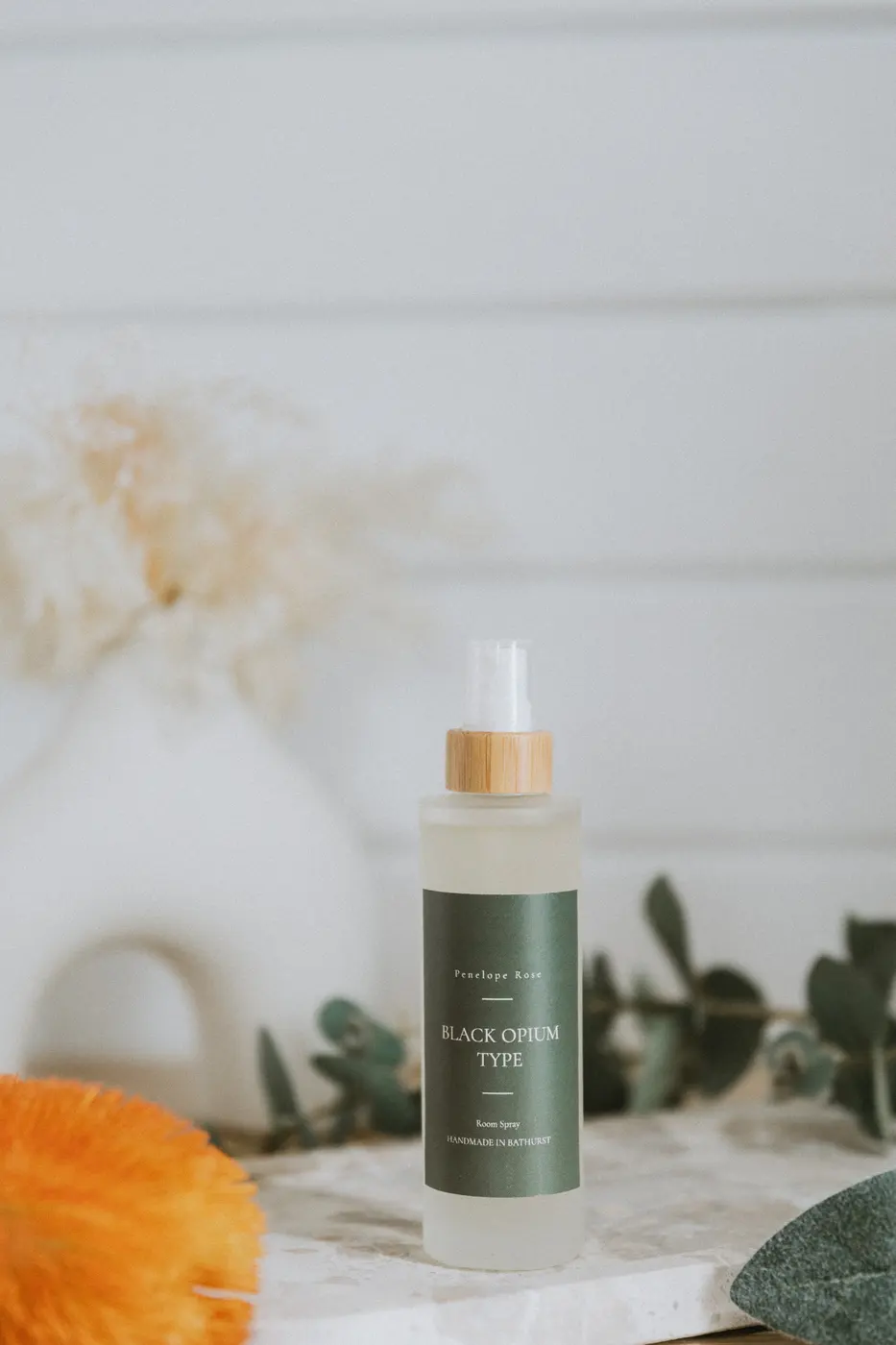 Frosted glass room spray with a bamboo pump top and eucalyptus foreground